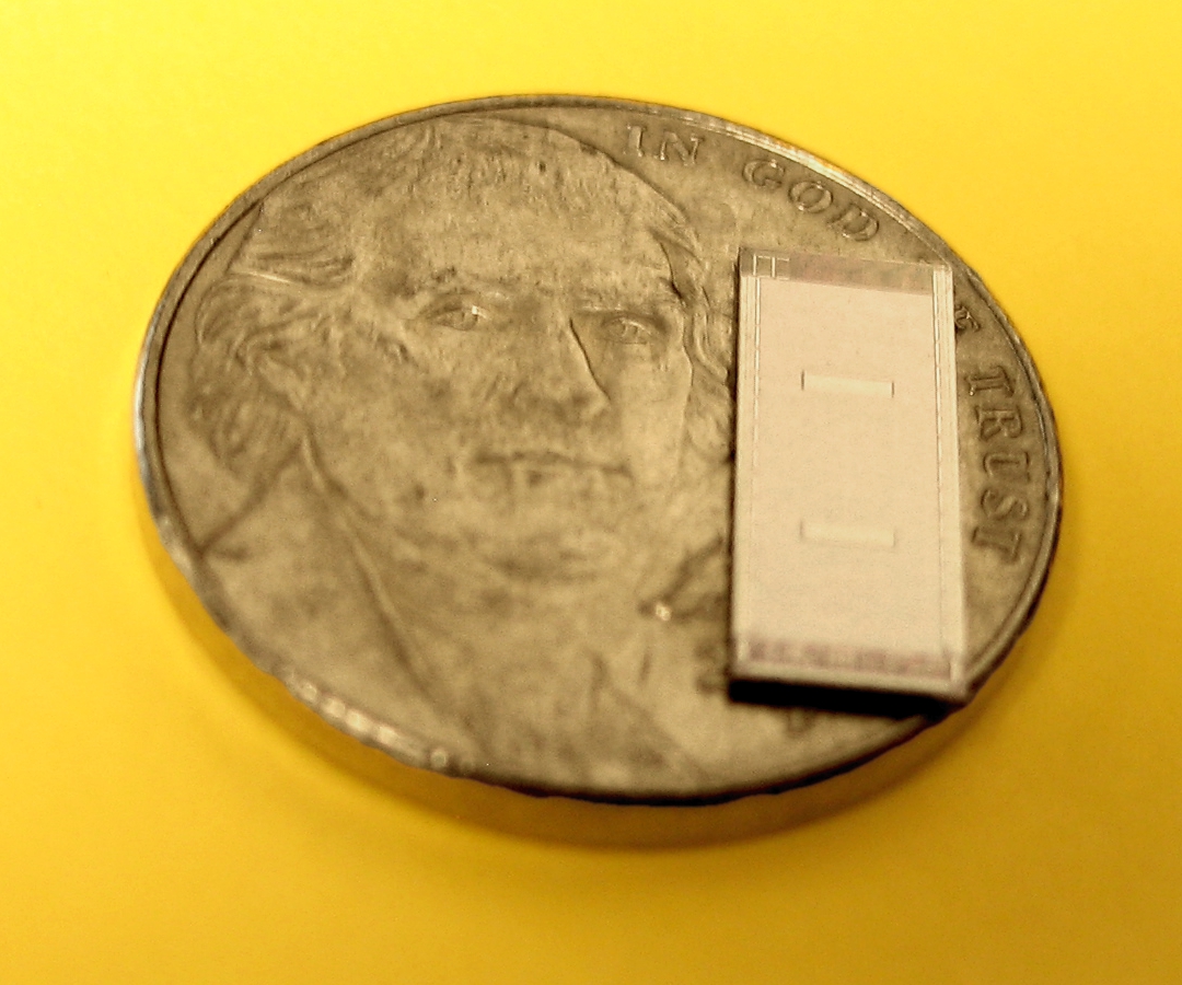 A two-layer die (with nickel for scale)